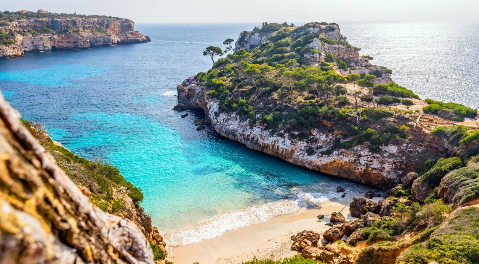 A turquoise cove enclosed by limestone cliffs on Mallorca's coast