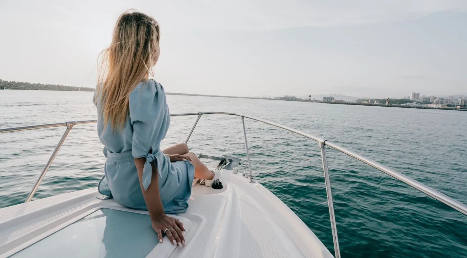 A passenger sitting on the bow of a boat watching the Mallorcan coastline