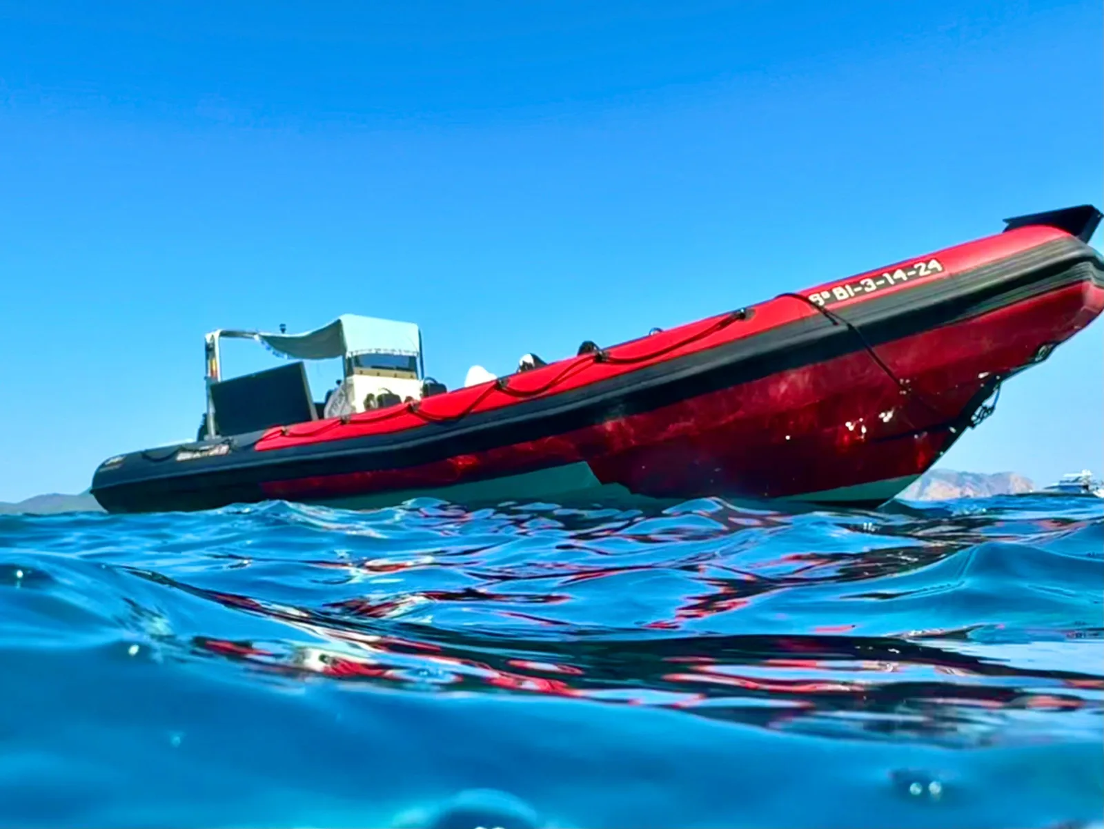 JetFun's red speedboat on flat turquoise water off the north coast