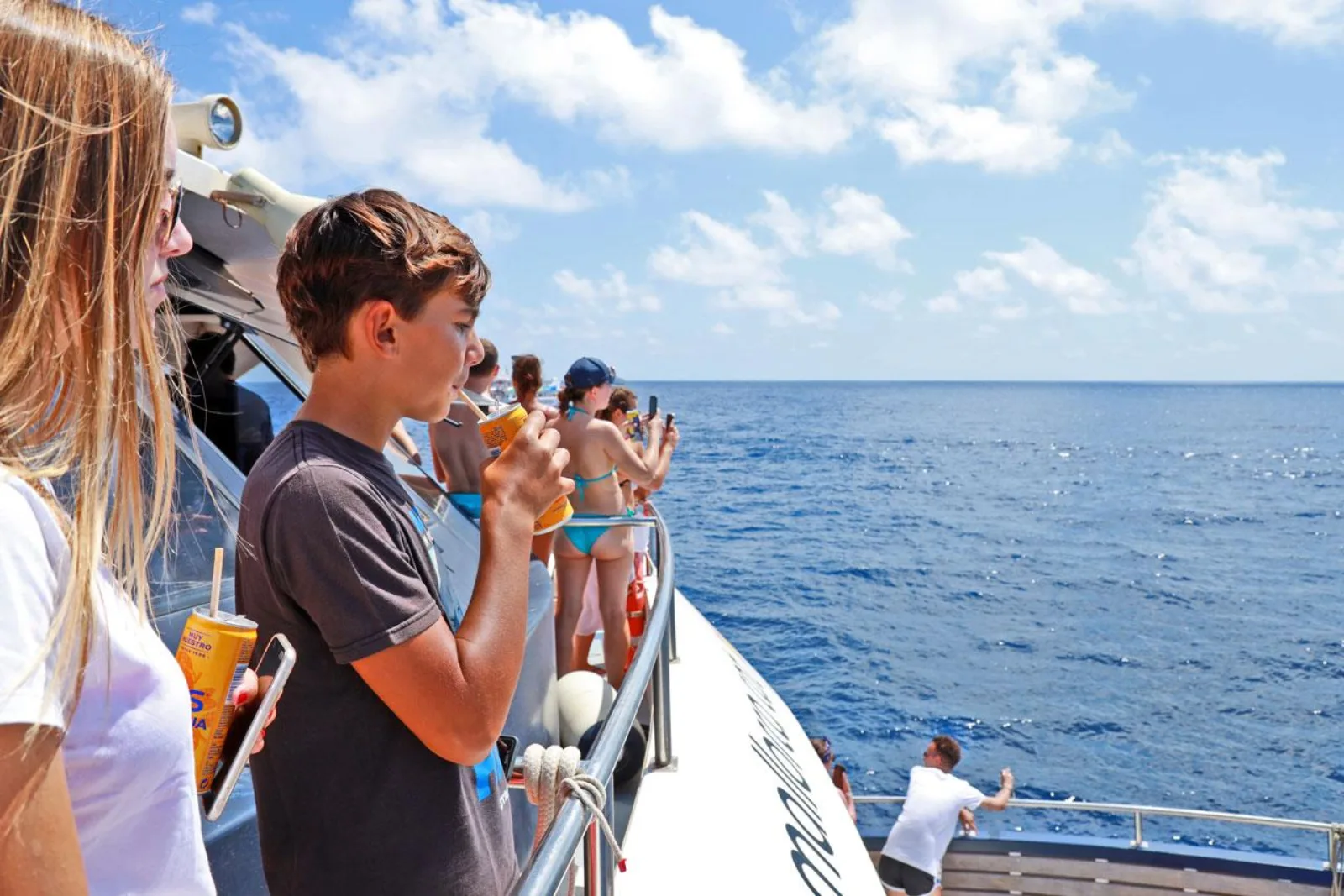 Guests with drinks from the on-board bar as the coast goes past