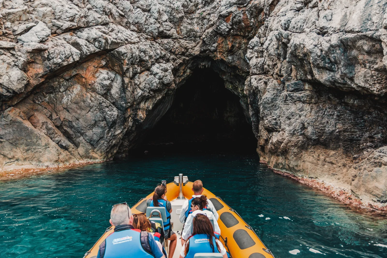 The boat entering a sea cave in the cliffs of the north coast