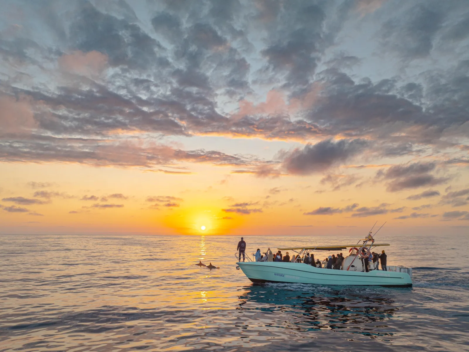 The boat silhouetted against the sunrise with the sun on the horizon
